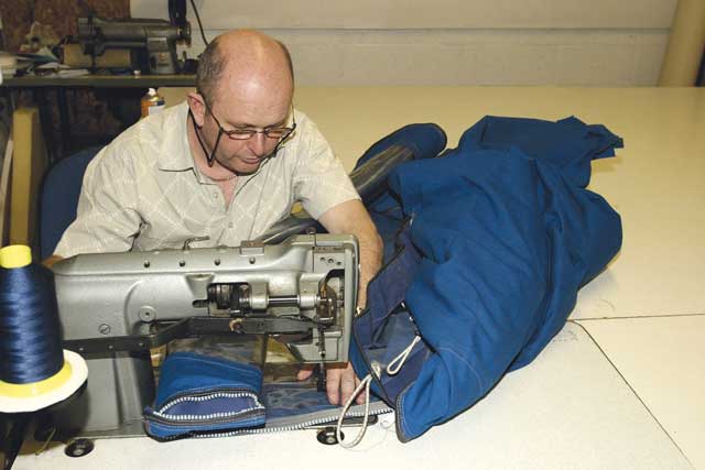 6 To tackle the last side of the window, Alan rolls the cover up to slide it through the machine. He can do this now there are three sides securely sewn, rather than just held by tape.