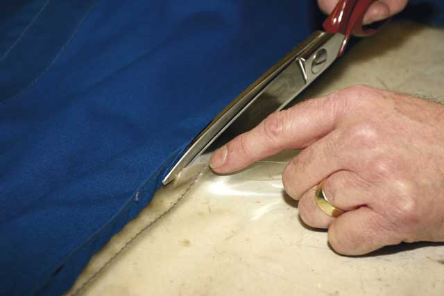 2: Once the scissors reach the outer seam, Alan teases back the fabric and snips along the seam a couple of millimetres clear of the fresh stitching. Taking his time, he carefully works along all four sides of the old window...