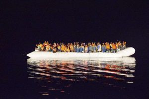 A boat filled with refugees and migrants crossing the Mediterranean floats off the coast of Italy. © Italian Navy-Masimo Sestini