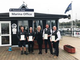 Four men and a woman stand at Shamrock Quay, MDL Marina, with their awards