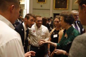 Royal patron of the UKSA Princess Royal in a green dress talking to sailors