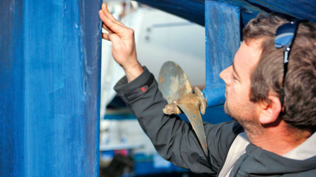 A man inspecting boat rudders