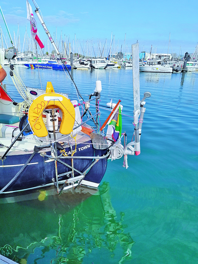 A rudder on the back of a boat moored alongside a pontoon