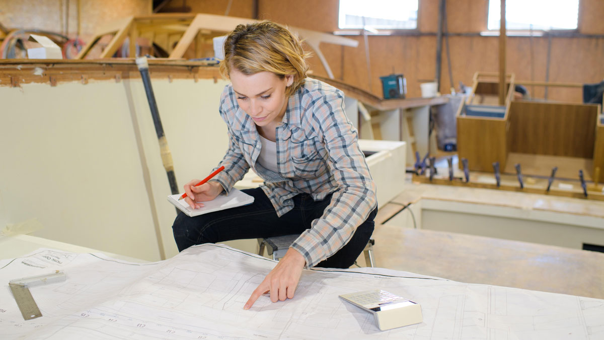 A women boatbuilder looking at a plan