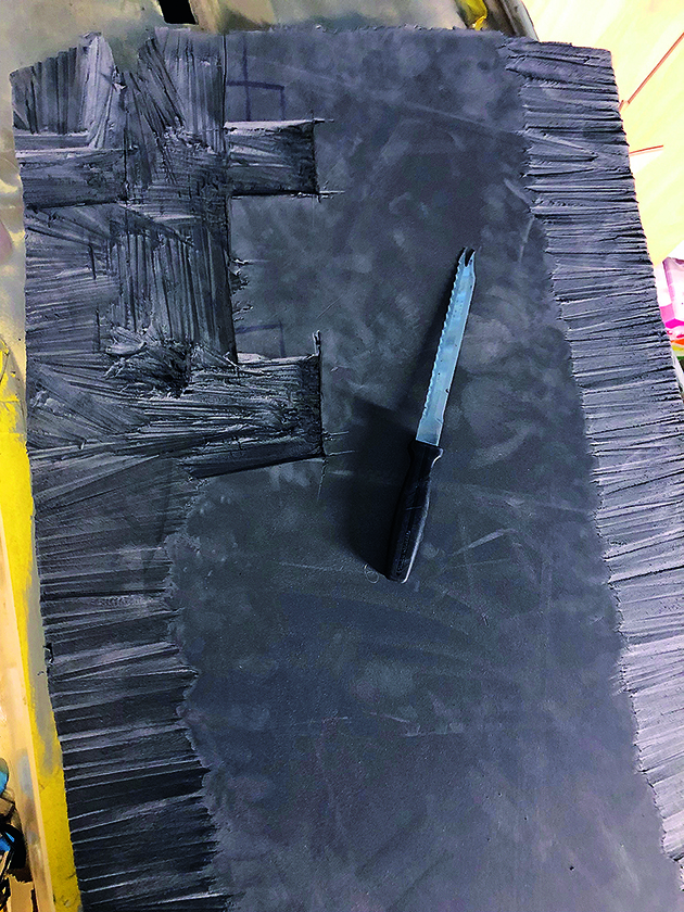 A knife lying on top of black hull insulation