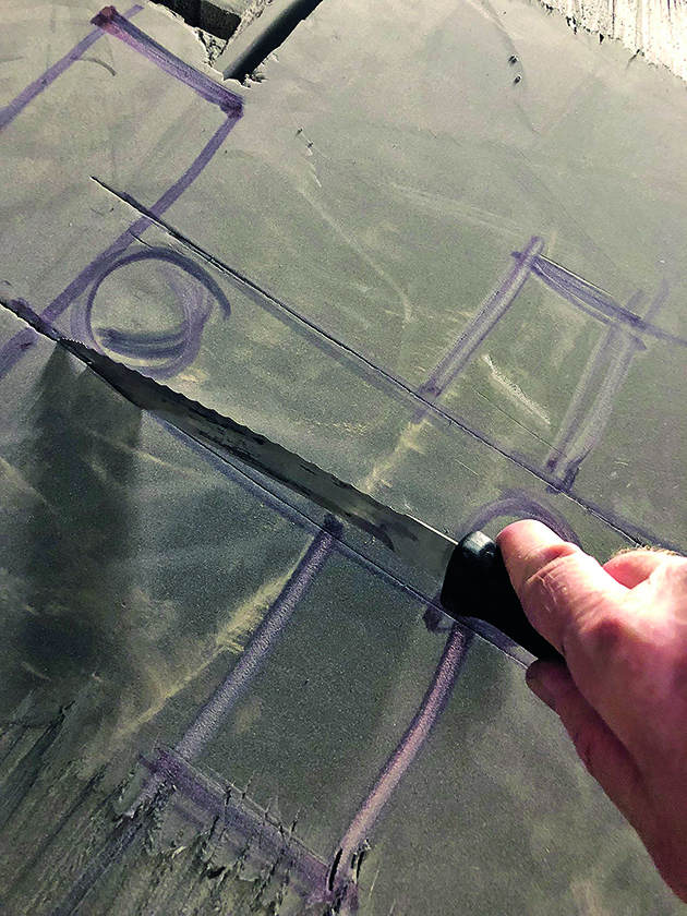 A man using a knife to cut hull insulation