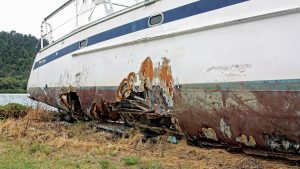 A boat with a hole in the white hull making it a boat write-off