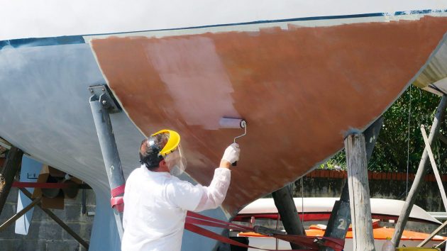 A man overcoating Coppercoat antifouling on a boat hull
