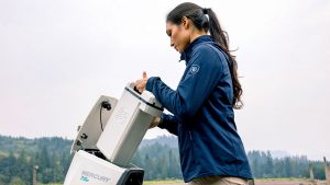 A woman removing a battery from an electric boat engine