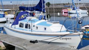 A white yacht moored by a pontoon
