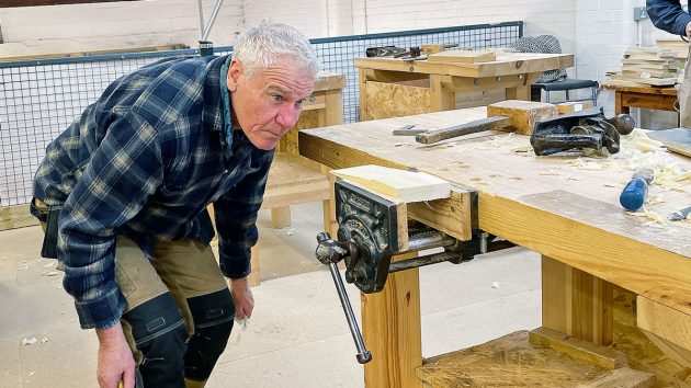 A man looking at a piece of wood