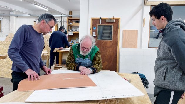 A man looking at a piece of wood