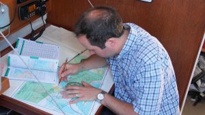 A man working on a chart during a blind navigation exercise