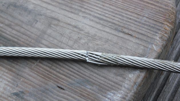 A wire, partially cut on a wooden pontoon