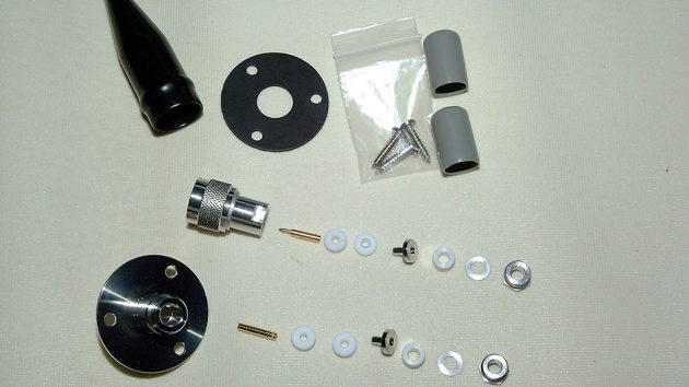 The plug and socket laid out in order. From right to left: backing nut – washer – cable seal – insert – first insulating seal – second insulating seal – pin – body. Note the blanking plugs and watertight cover