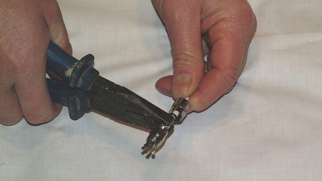 4. Using pliers, squeeze the arms of the fitting so that they pierce the outer insulation and make contact with the braid. It does not need a lot of pressure to satisfactorily pierce the braid.