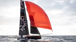 A boat with red and black sails heading out into the Atlantic for a small boat Atlantic crossing attempt