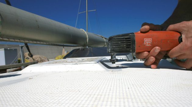 A man using a multi tool on the deck of a boat