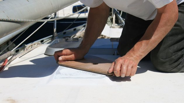 A man sanding the deck of a boat