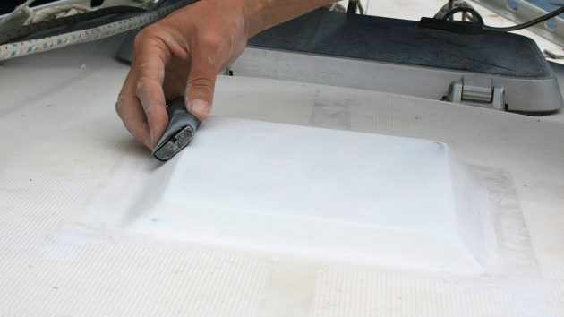 A man sanding a mast step on a boat