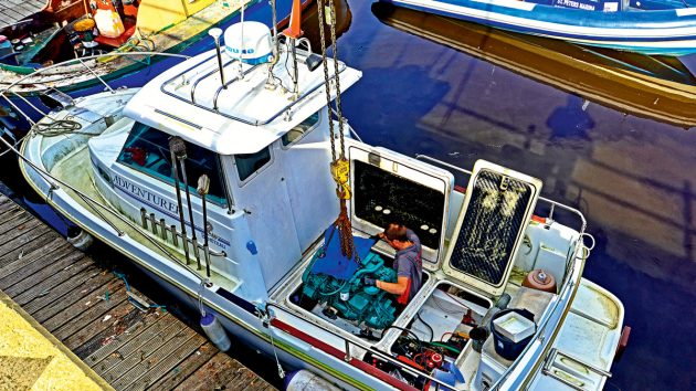 A man removing an engine from a boat which would require another boat certification in the UK