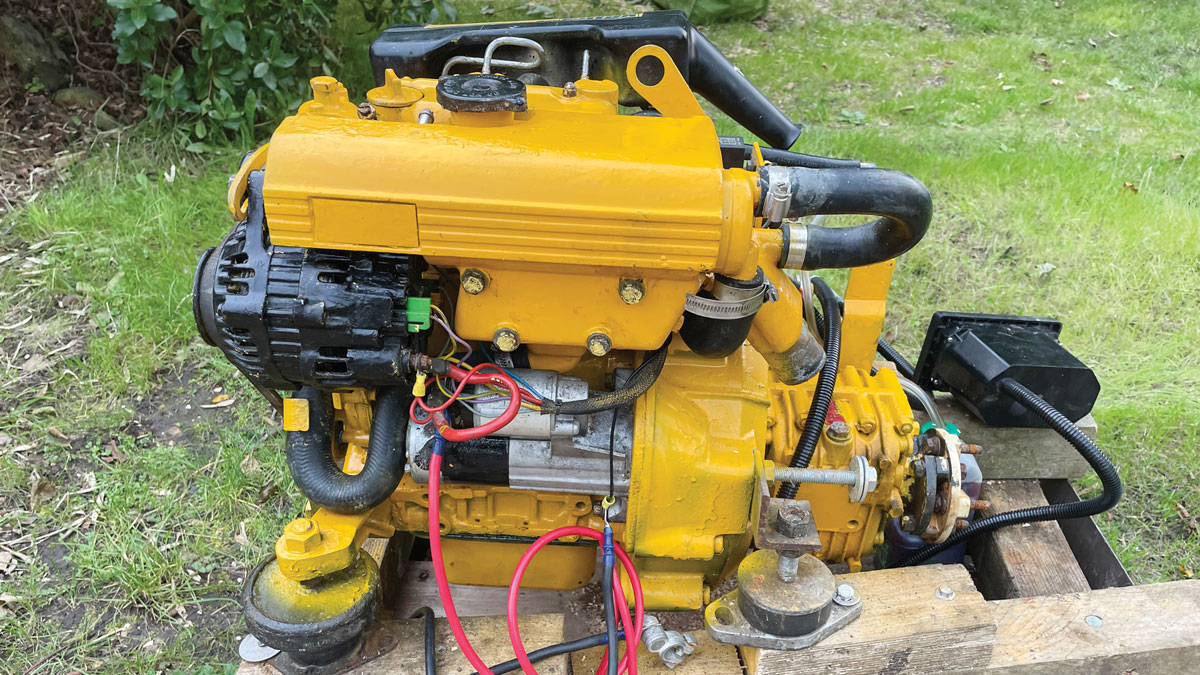 A yellow diesel engine on a boat standing on wooden blocks