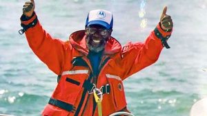 Bill Pinkney giving a thumbs up dressed in red oil skins