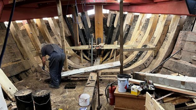 A man working on the ribs of a boat