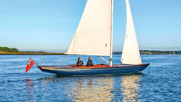 A 30 foot wooden boat sailing in flat water