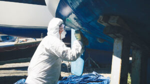 A person antifouling a boat