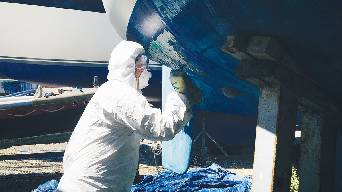 A person antifouling a boat