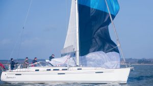 A crew dropping a cruising chute on a yacht