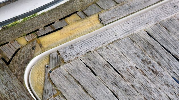 part of a teak deck which is in a bad state of repair on a yacht