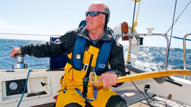 A man steering a boat with a wooden tiller