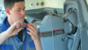 A man servicing an engine as part of effort to save fuel when motoring a boat