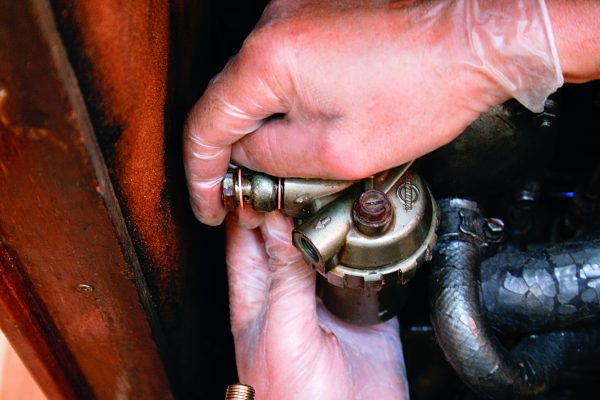 A man working to repair an engine leaks on a boat