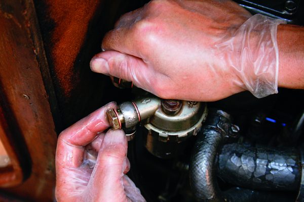 A man working to repair an engine leaks on a boat