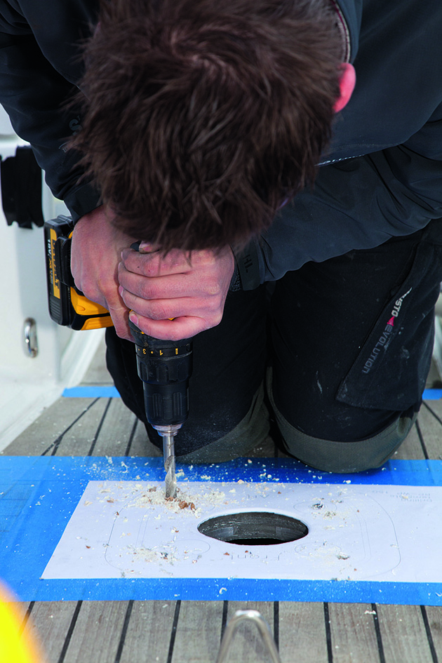 A man drilling a hole on a boat