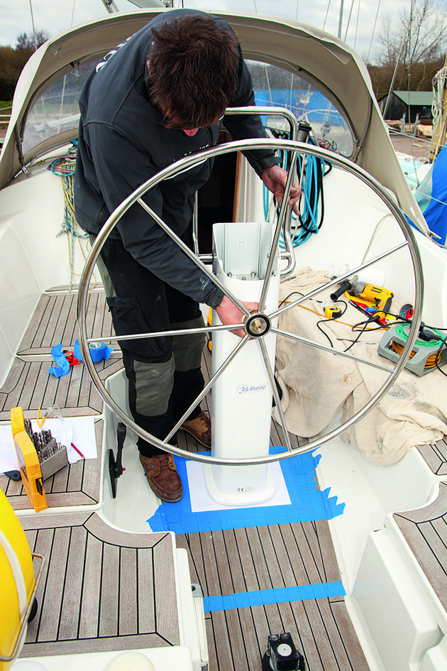 A man moving a wheel on a boat