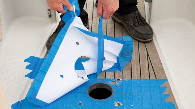 Template and masking tape being removed from a boat