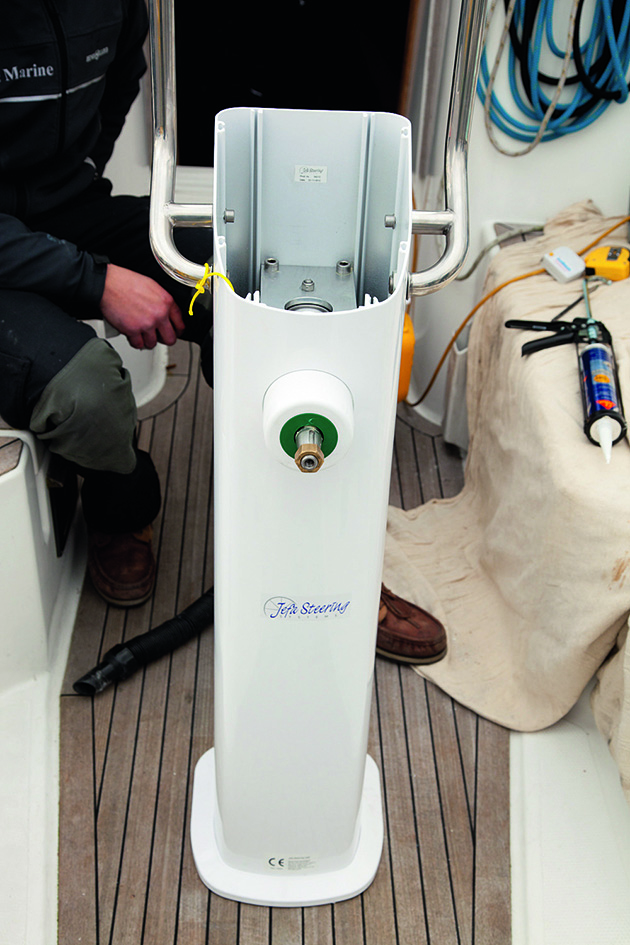 A pedestal being lowered into place on the deck of a boat as part of tiller to wheel conversion