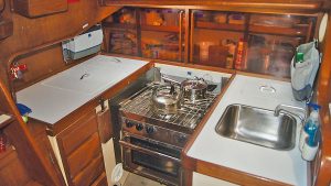 A boat galley with an oven, sink and fridge