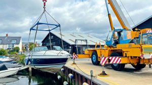 A boat being lifted out of the water by a crane