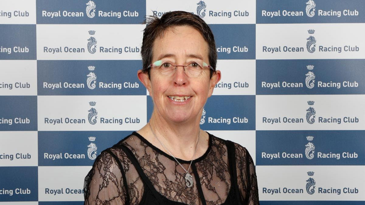 Dr Deborah Fish, standing in front of a Royal Ocean Racing Club sign
