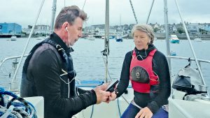 Two people using a crew headset to help with anchoring on a boat