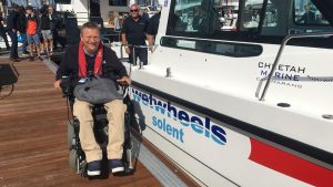 Geoff with his Wetwheels Solent accessible Cheetah power catamaran at the Southampton International Boat Show