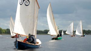 A fleet of sailing boats race towards Tarmonbarry on the River Shannon in Ireland