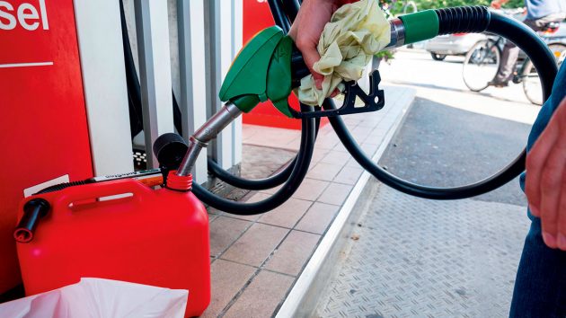 A person using a petrol pump to full up a fuel can