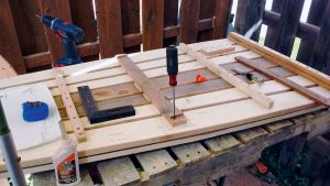 A man making a cockpit grate out of wood