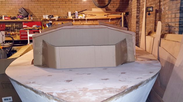 A motorboat being built in a garage